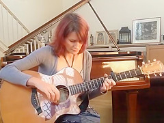 Redhead playing guitar down blouse and cleavage