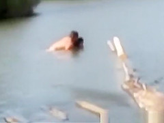 The couple having sex in the water in the pond.