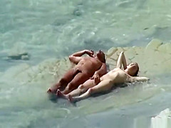 Nudist pair sunbathing and refreshing