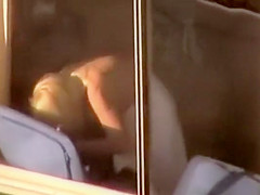 Topless chick standing by the window