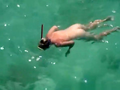 Nudist woman swimming in the water