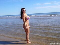 Breasty bikini model likes the beach