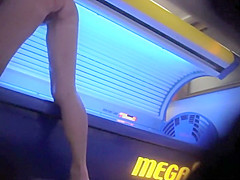 Aged lady wipes the tanning machine