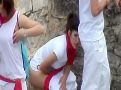 Uniformed cuties pissing behind a car