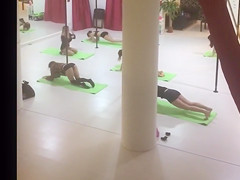 Scarcely-dressed stripteasers stretch in advance of dancing on poles