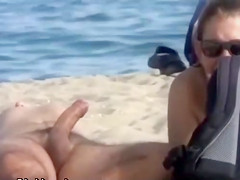 Wife strokes his half hard rod at the beach
