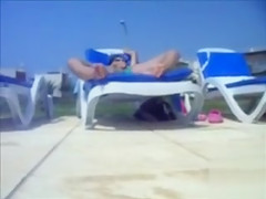 My wife in lounge chair stimulates her love button poolside