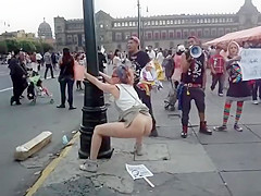 Female agitator pees and poops on a poster at a rally in protest to the government