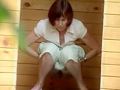 Pissing aged woman zoomed by a voyeur