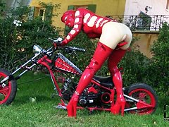 Latex Lucy in latex costume is fingering muff