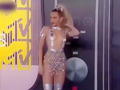 Scantily clad Miley Cyrus positions for photographers