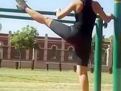 Supple woman in spandex stretches in the park