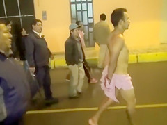 Cops walk a not quite undressed criminal down the street