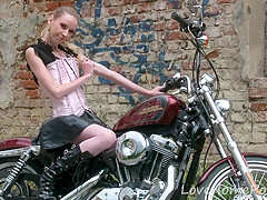 Cute legal age teenager is amazed by a large bike
