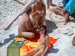 Il tripote une jeune nana à la plage devant son épouse