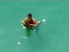 Pair giving a kiss and fucking in the water