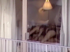 Voyeur zooms on sex in a hotel room